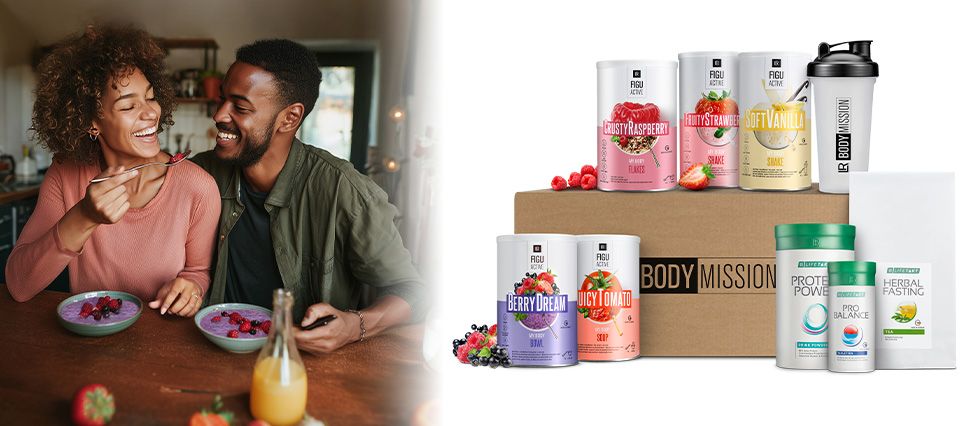 Ein Paar am Frühstückstisch, daneben das Paket der LR Body Mission mit FiguActive-Dosen und Begleitern