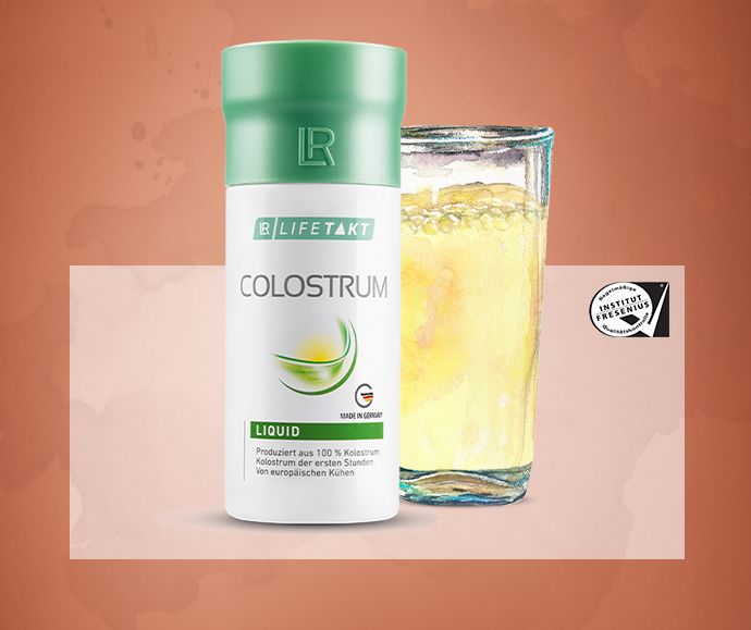 A bottle of Colostrum Liquid next to a filled glass